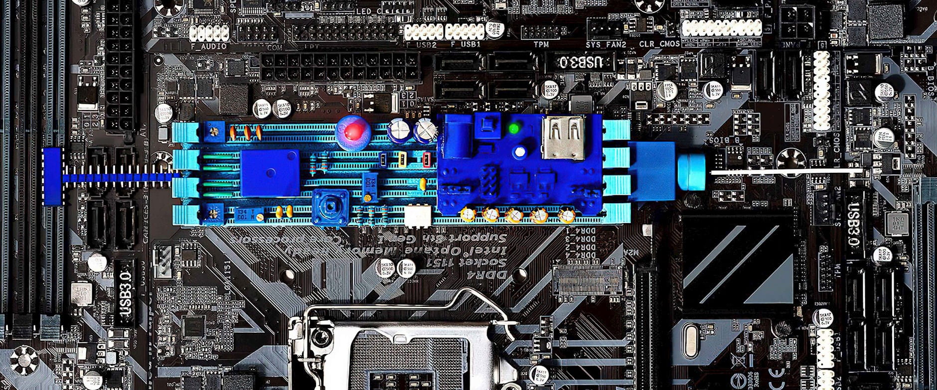 Black and white motherboard with a color component syringe in the center 