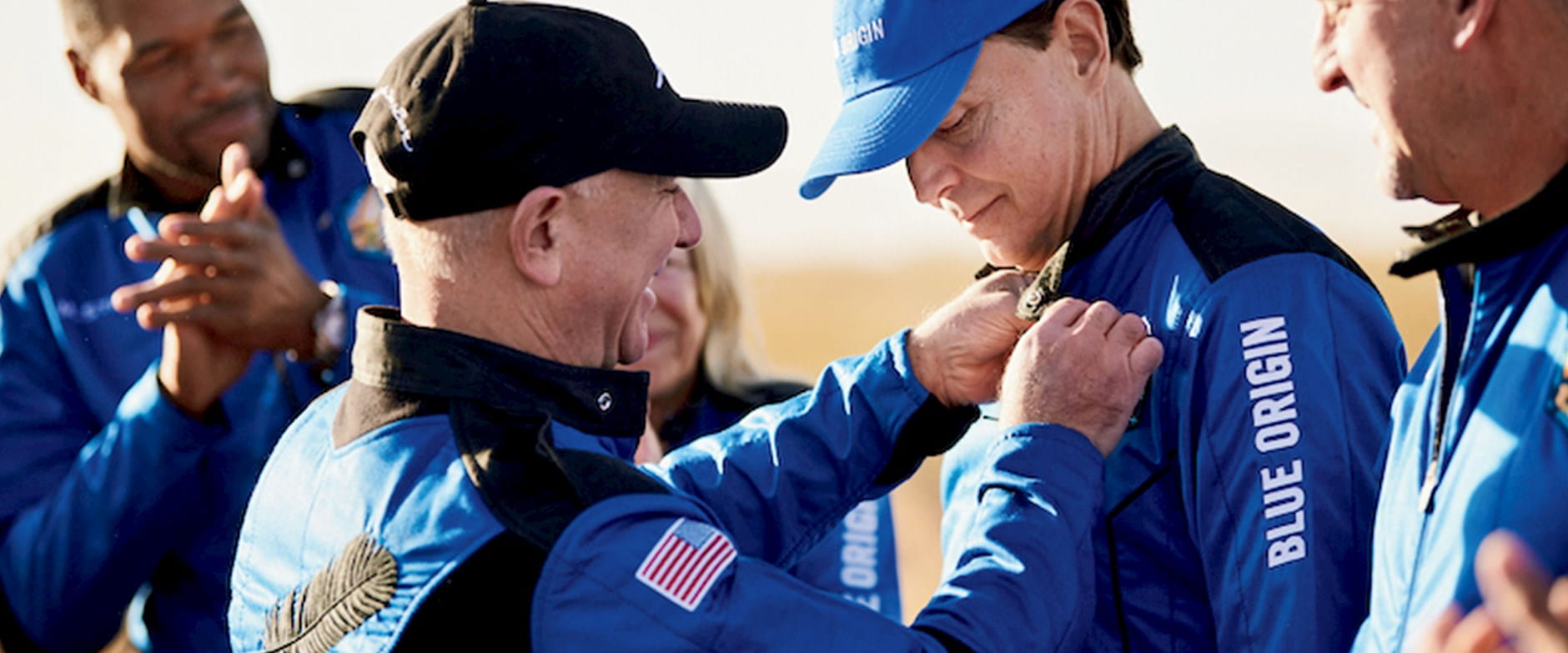 Members of Blue Origin space exploration receiving pins on their uniform
