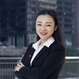Chelsy Cheng, an Asian woman in a suit jacket and white button down, smiles at the camera