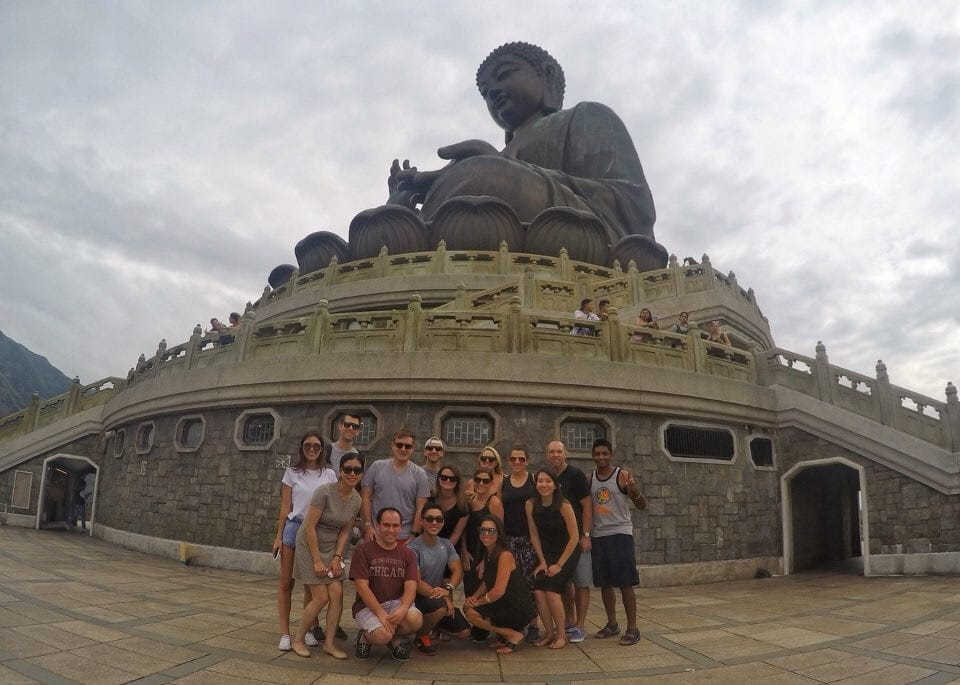 Group of Chicago Booth students pose in front of large Buddha monument in Hong Kong.