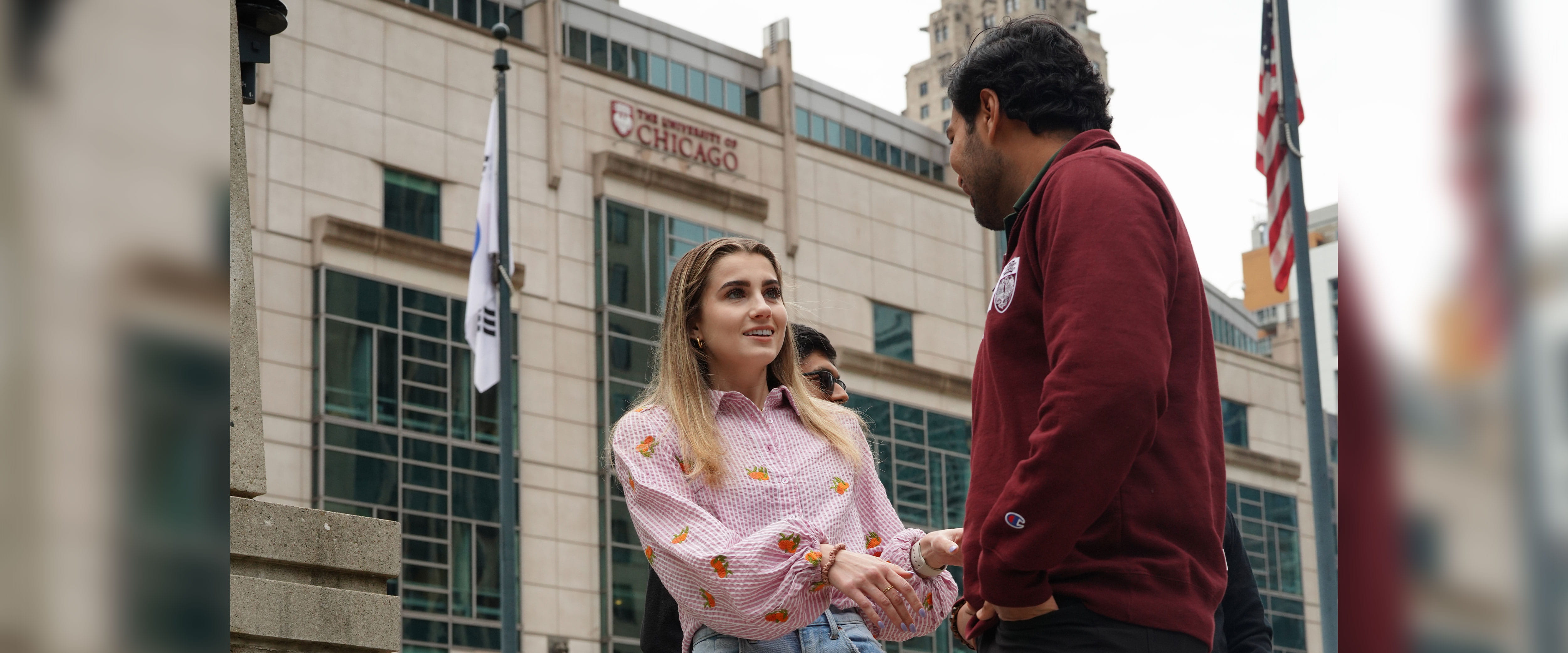 Booth students conversing outside of Gleacher Center