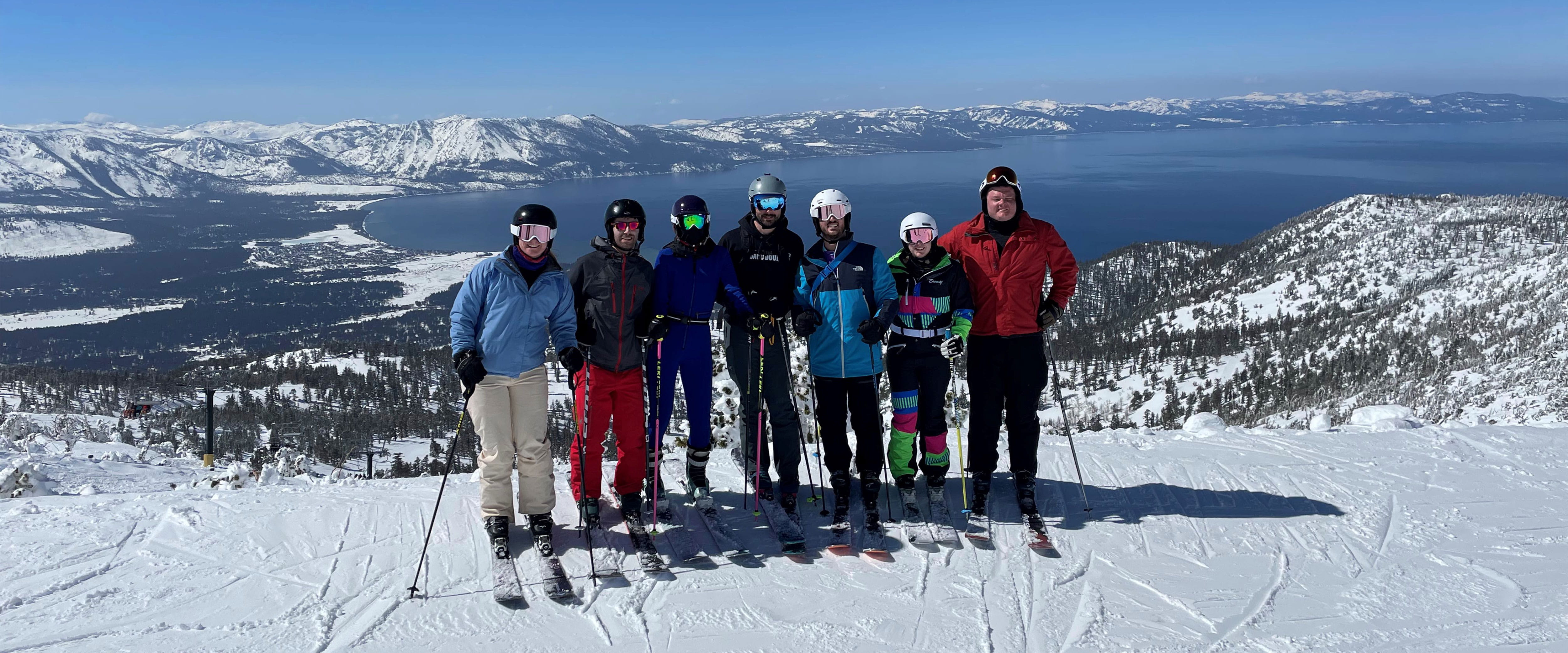 Booth students at Evening Weekend Ski Trip with coats on ski gear on posing in front of snowy mountain
