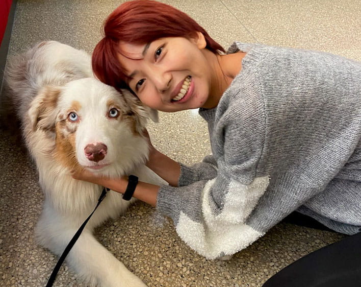 woman posing with dog smiling with face close to dogs face