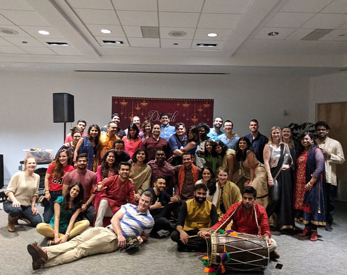 large group of Boothies taking group photo indoors 