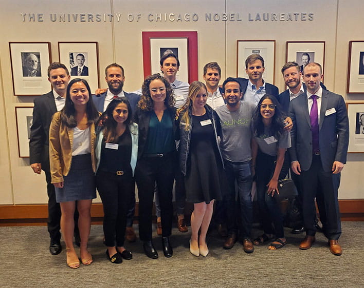 13 Boothies posing together inside of the Gleacher Center
