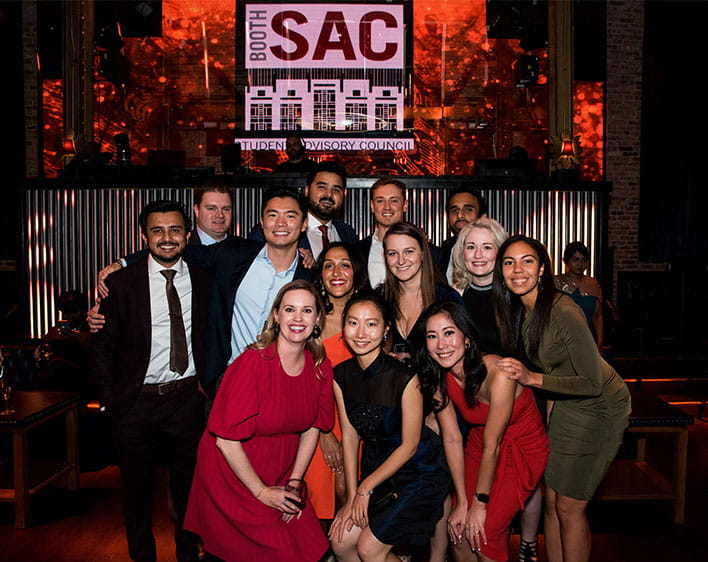 members of SAC smiling together with SAC sign in background 