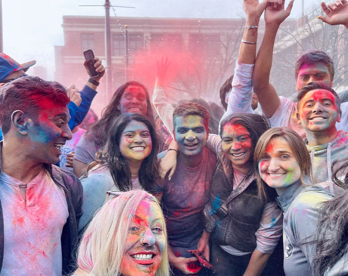 members of Booth South Asian Club covered with spray paint smiling 