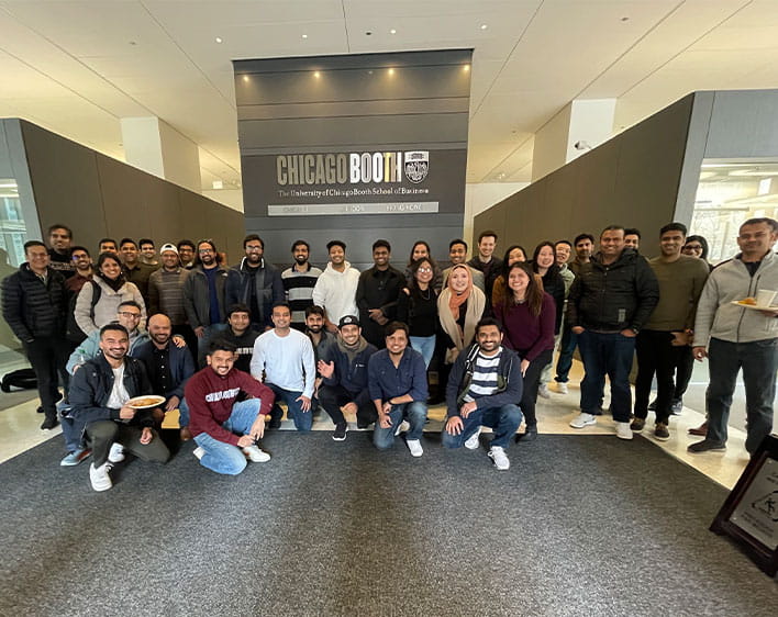 Booth South Asian Club members posing outside Chicago Booth sign
