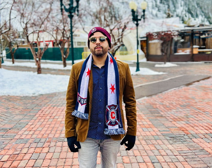 Gil Jimenez outside with coat, sunglasses, and gloves on 