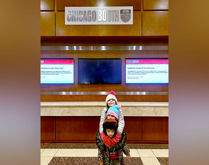 Gil Jimenez's three children hugging eachother with coats on inside of the Gleacher Center