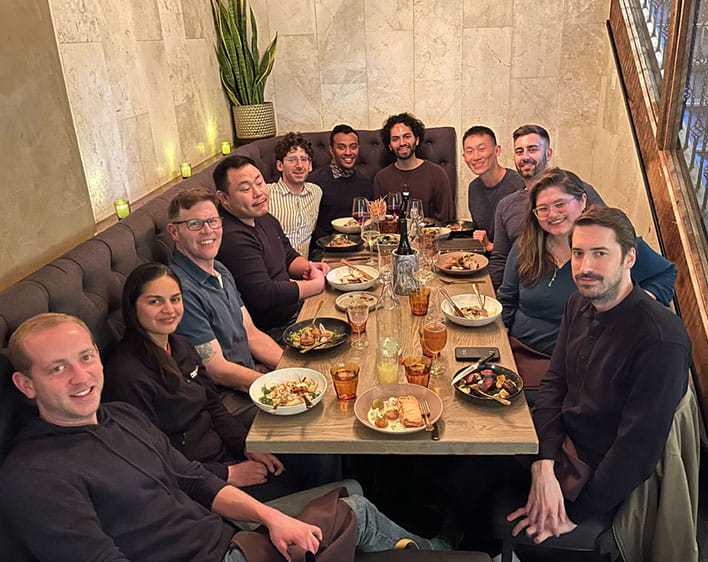 Group of 11 Boothies photographed indoors together at restaurant dinner table 