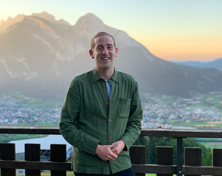 Ben Cohen outside smiling with mountian and sunset in the background
