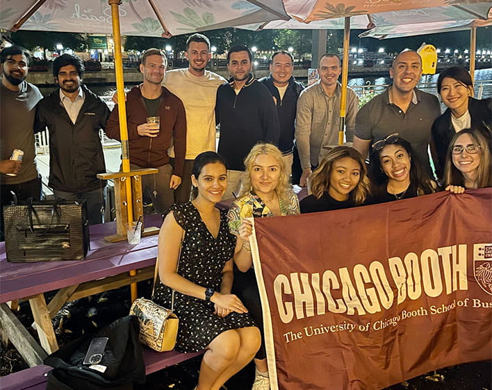 Enrique with other Boothies outdoors holding Booth flag