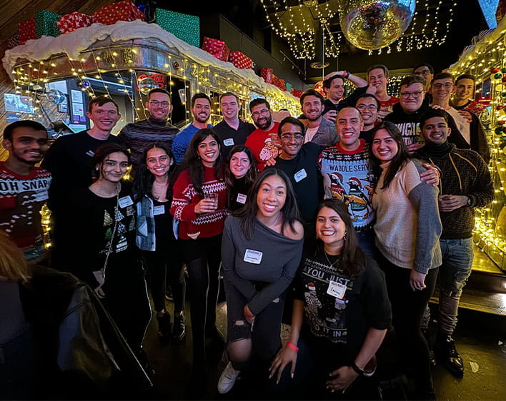 Group of Boothies photographed together, including Enrique Palomo at holiday party
