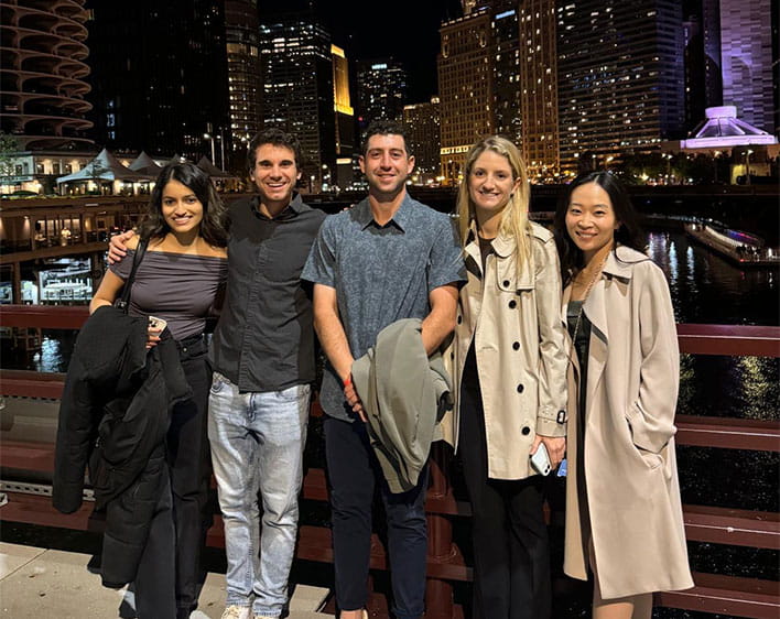 Kyle Balog with friends downtown at night with skyline in background