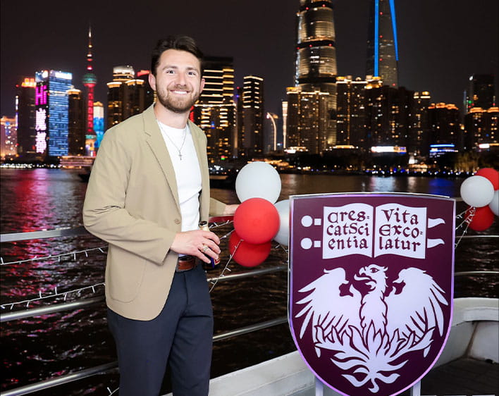 Michael on boat in front of Booth branded shield 