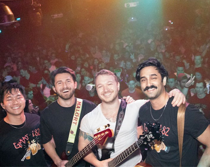 Michael with his bandmates in selfie with crowd in the background 