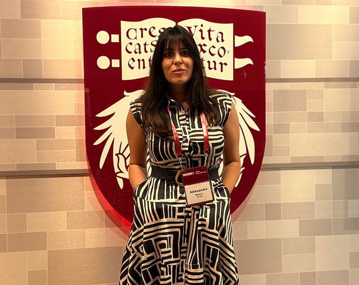 Aleksandra Matovic in front of The University of Chicago Crest on wall