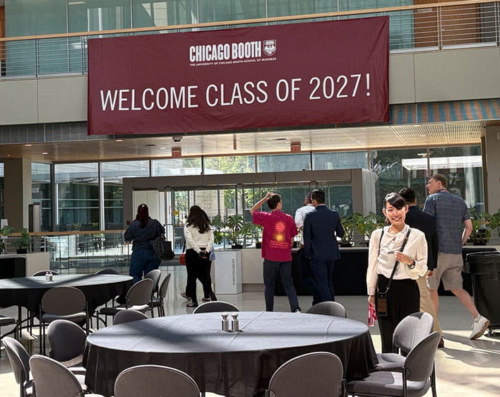 Ami Hamamoto in front of "Welcome Class of 2027" banner at the Harper Center