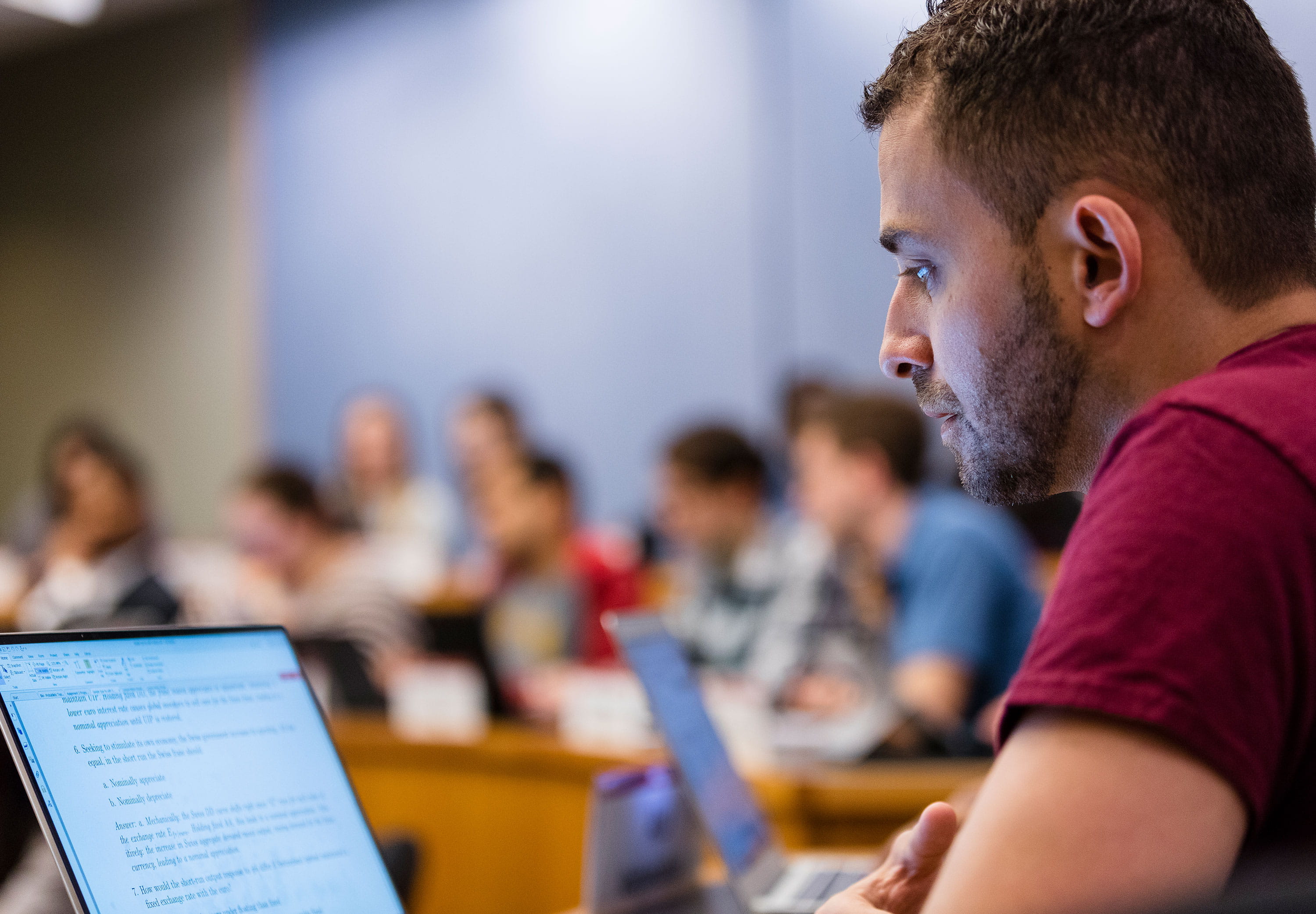 A male student works on his computer during class