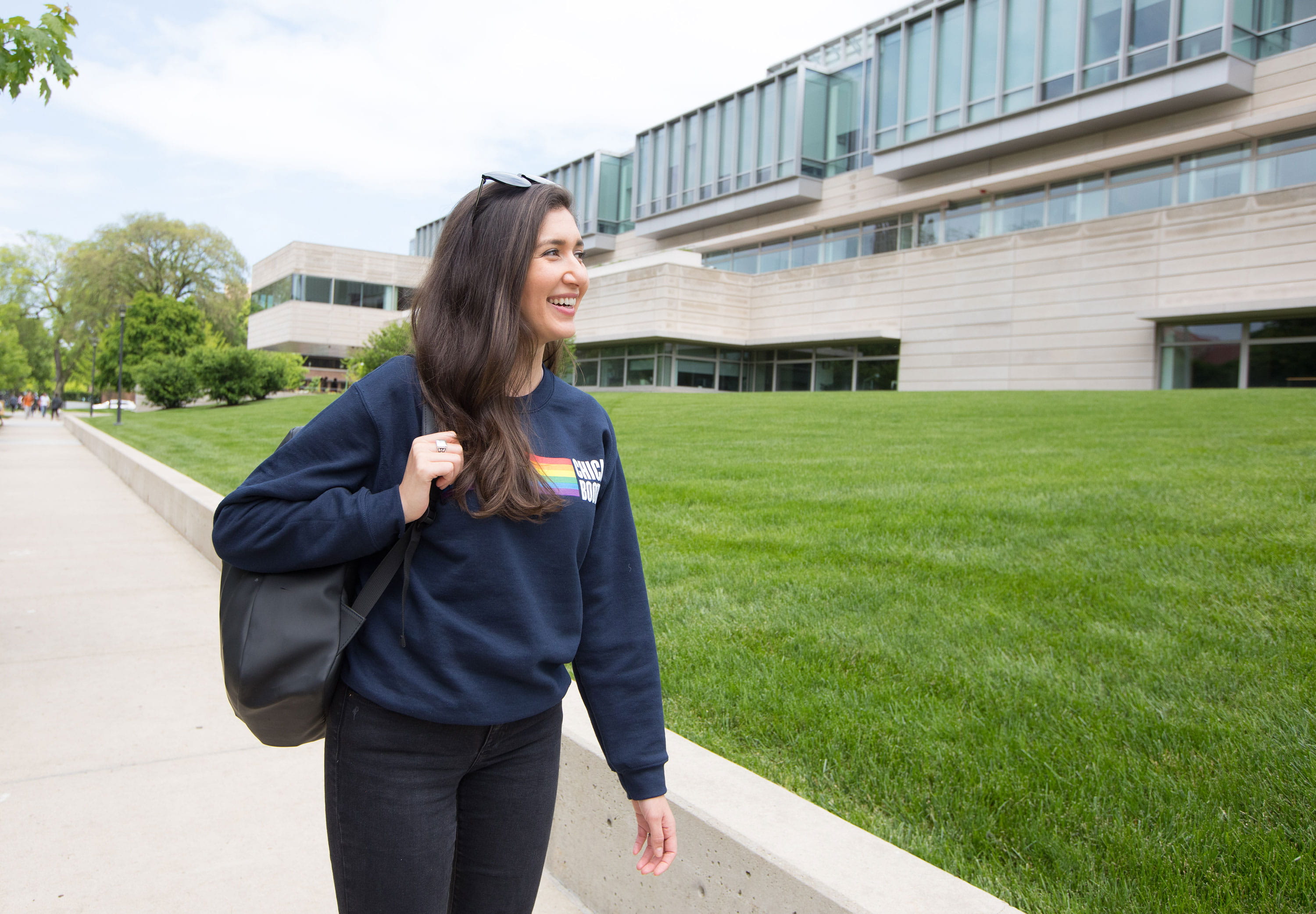 A female student walks in front of the Harper Center smiling