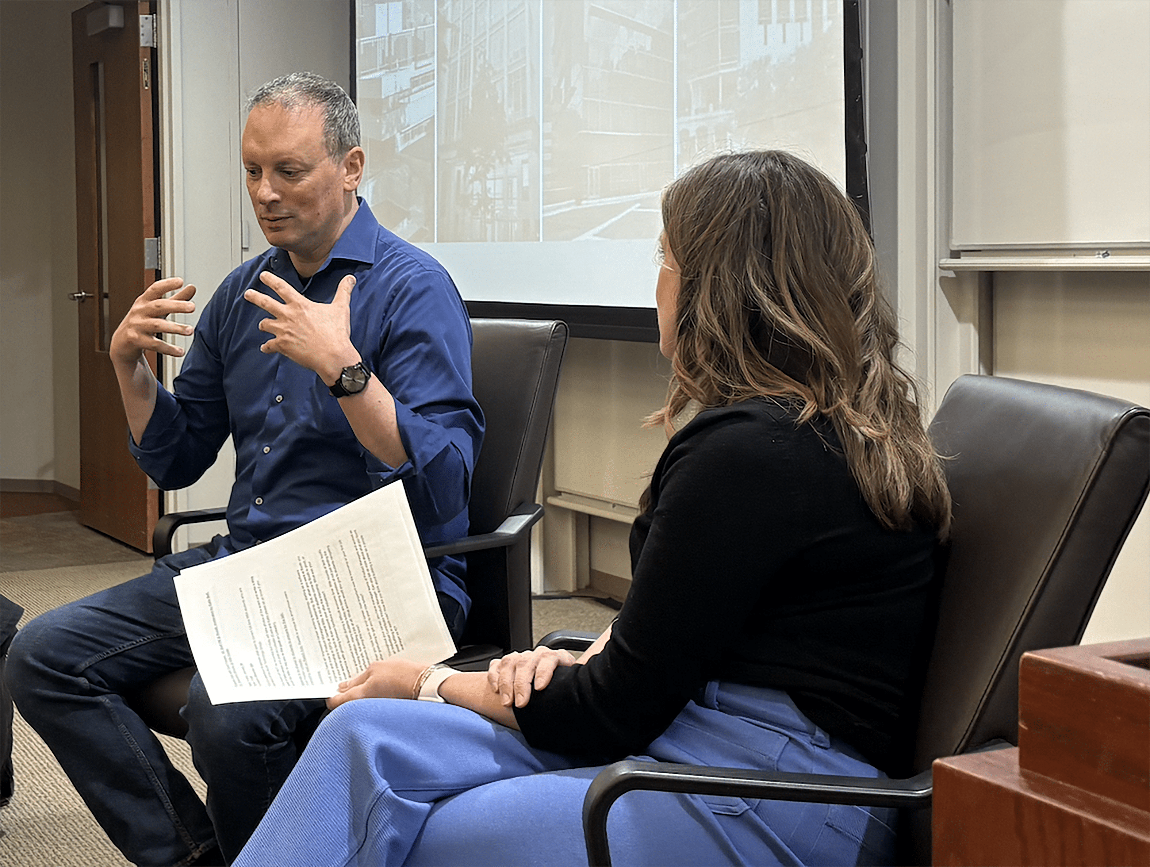 Man and woman sitting side-by-side discussing a topic.