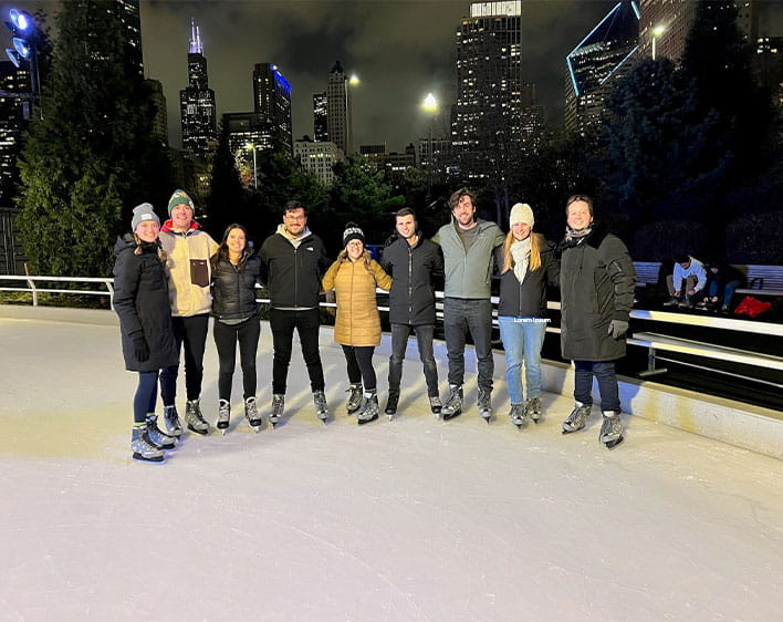 9 members of Booth Partners club on ice stating rink 