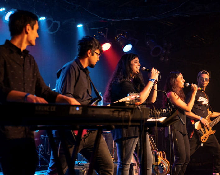 four AudioBooth members performing on stage