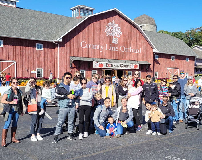 Group of POLO Boothies with their families posing together outside of Country Line Orchard
