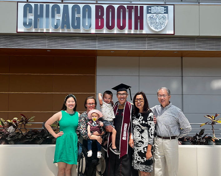 Jeff in his cap and gown with family inside of the Harper Center