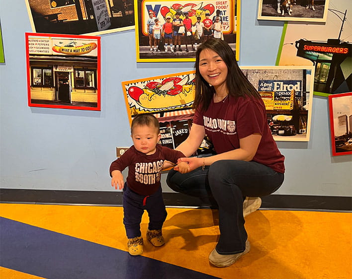Rae posing with her son in Booth gear at Partners club event