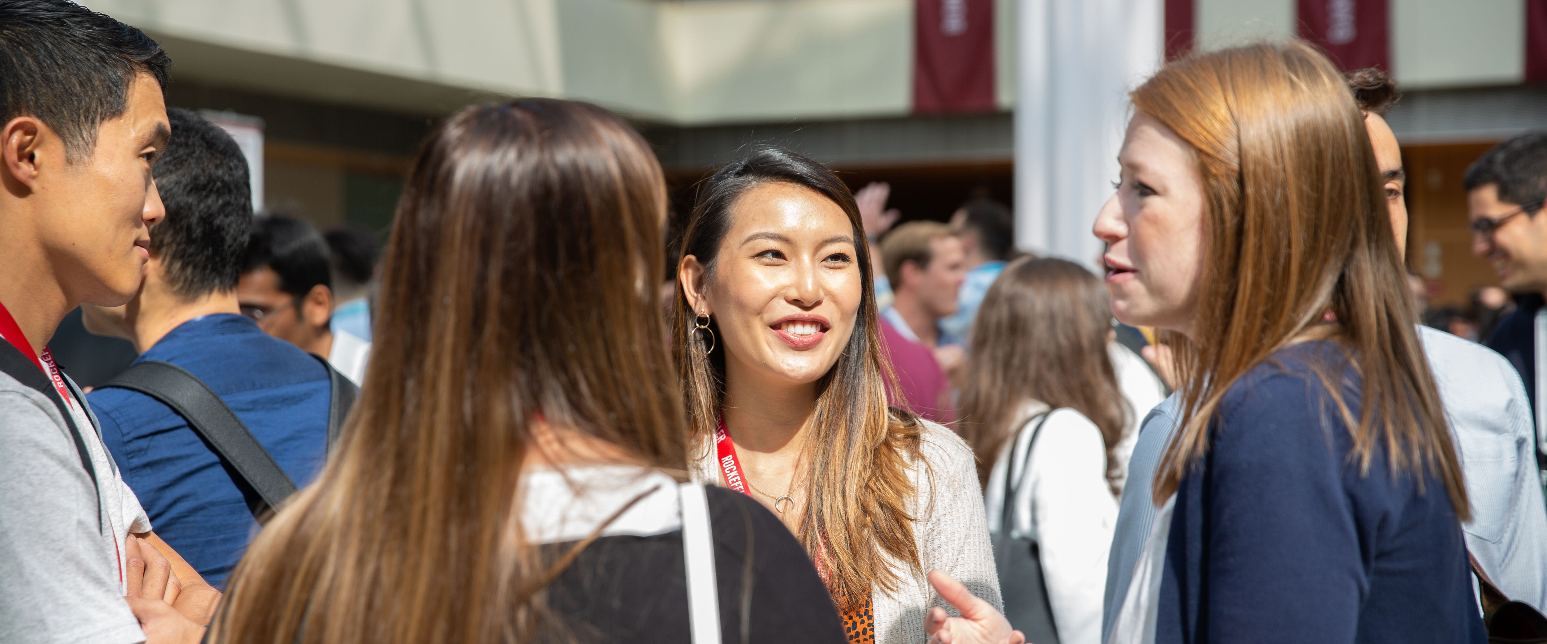 FTFY20 Orientation Capture First Day -- close up of four students smiling and conversing in Harper Center Winter Gardens