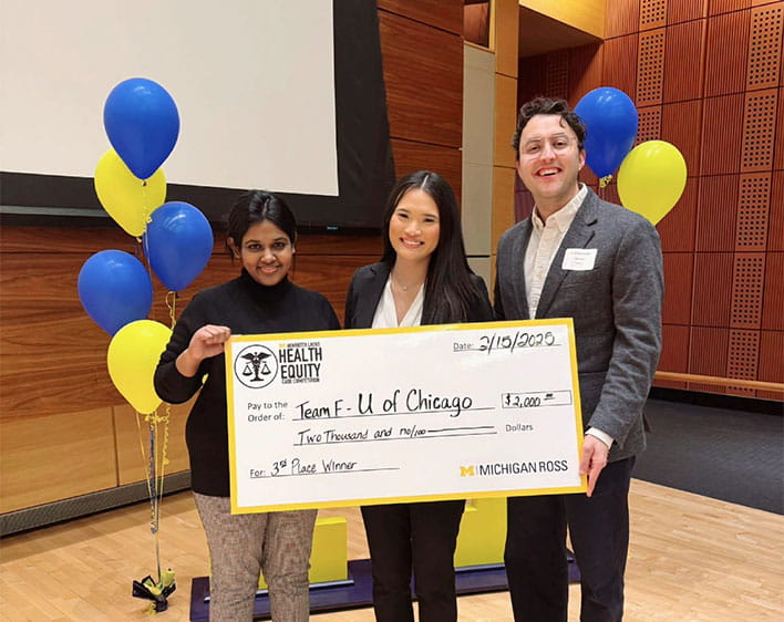 Deya and two other students holding up check award 