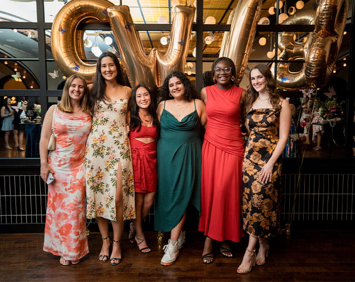Natalie Chun and other Boothies in dresses with CWIB balloons in background