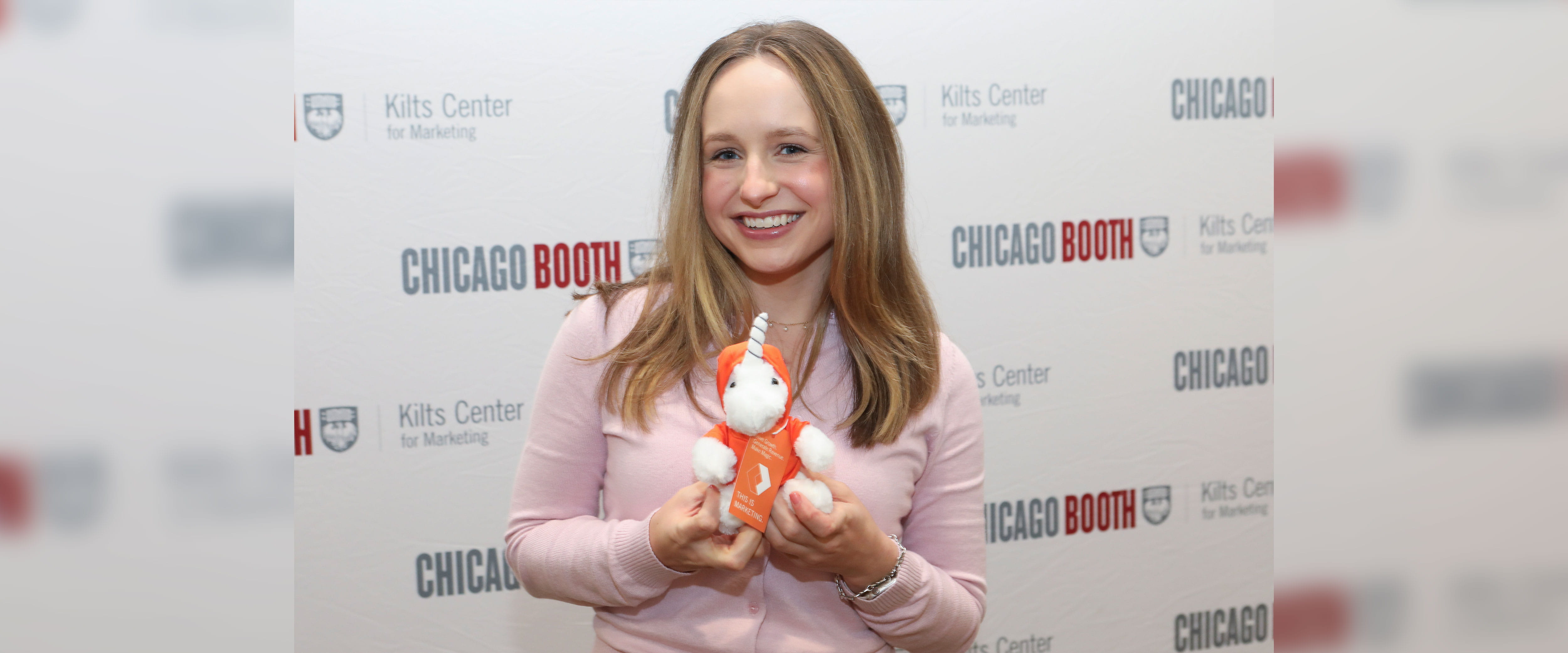 Kilts Fellow at Kilts Open House in front of Chicago Booth sign