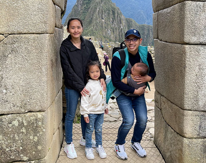 family photo of Nam with his wife and two kids outdoors