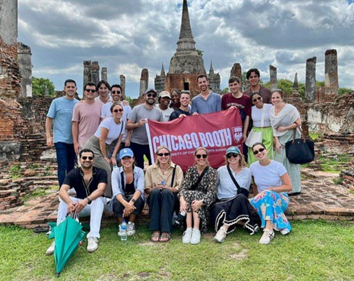 group photo of students with Booth flag at Random Walk trip
