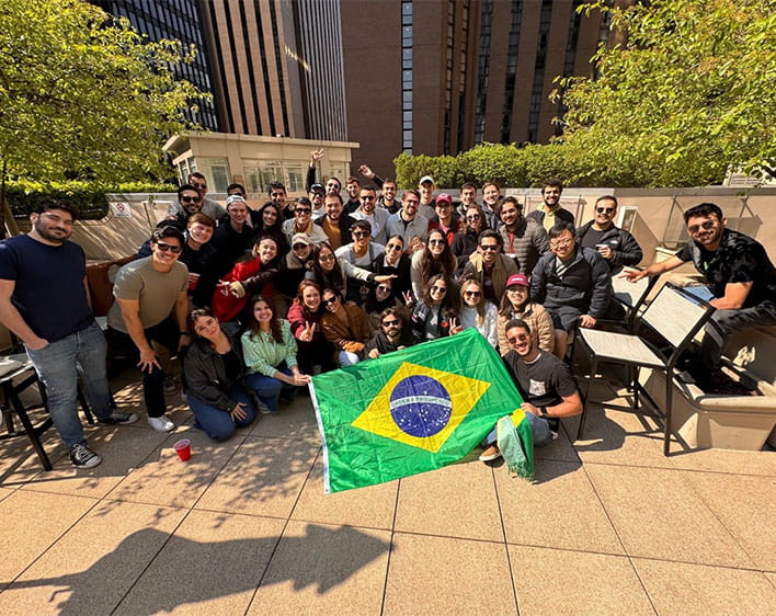 large group of students outside posing with Brazil flag