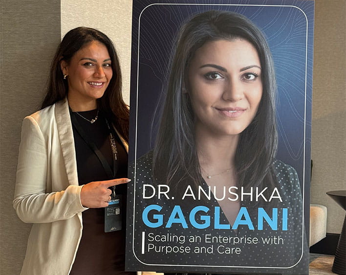 Anushka in front of signage with her name on it smiling 