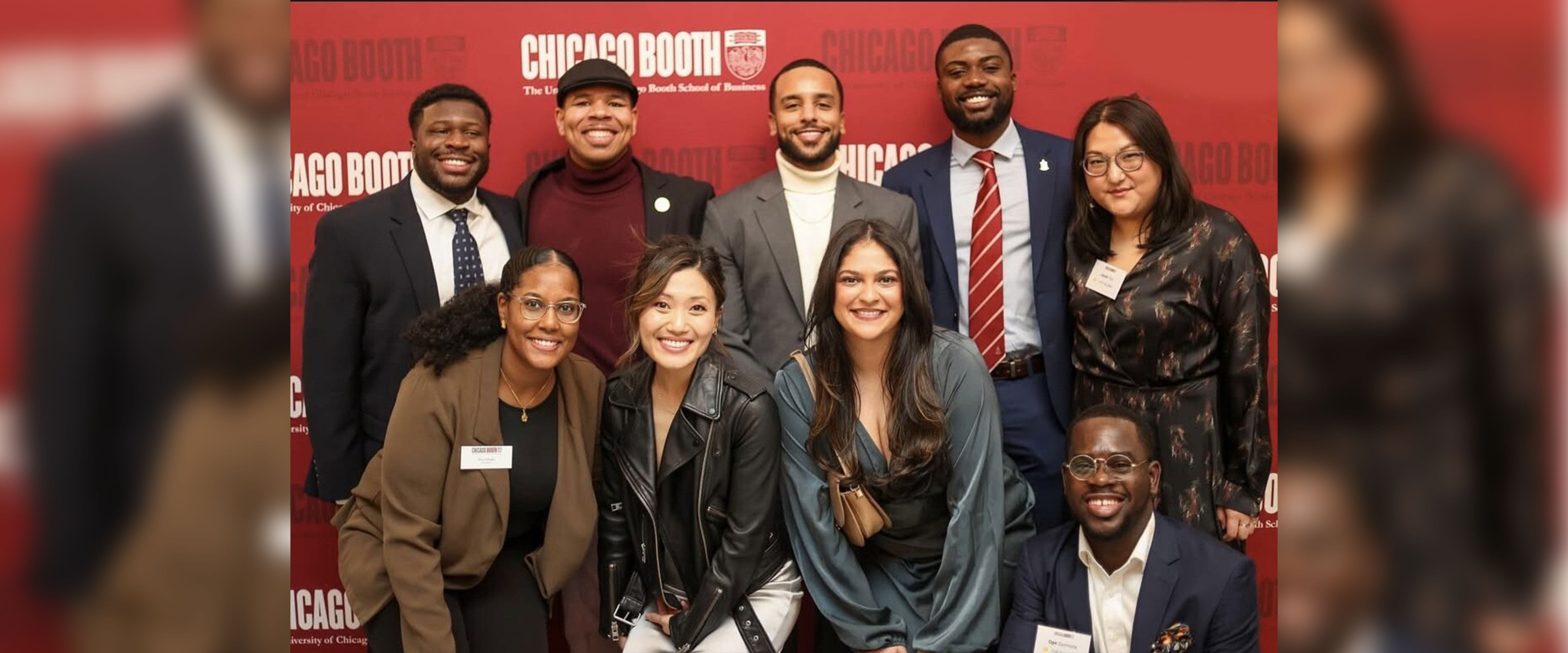 group photo of Dena Bashri and Boothies in front of Chicago Booth backdrop at the DuSable museum wearing formal wear