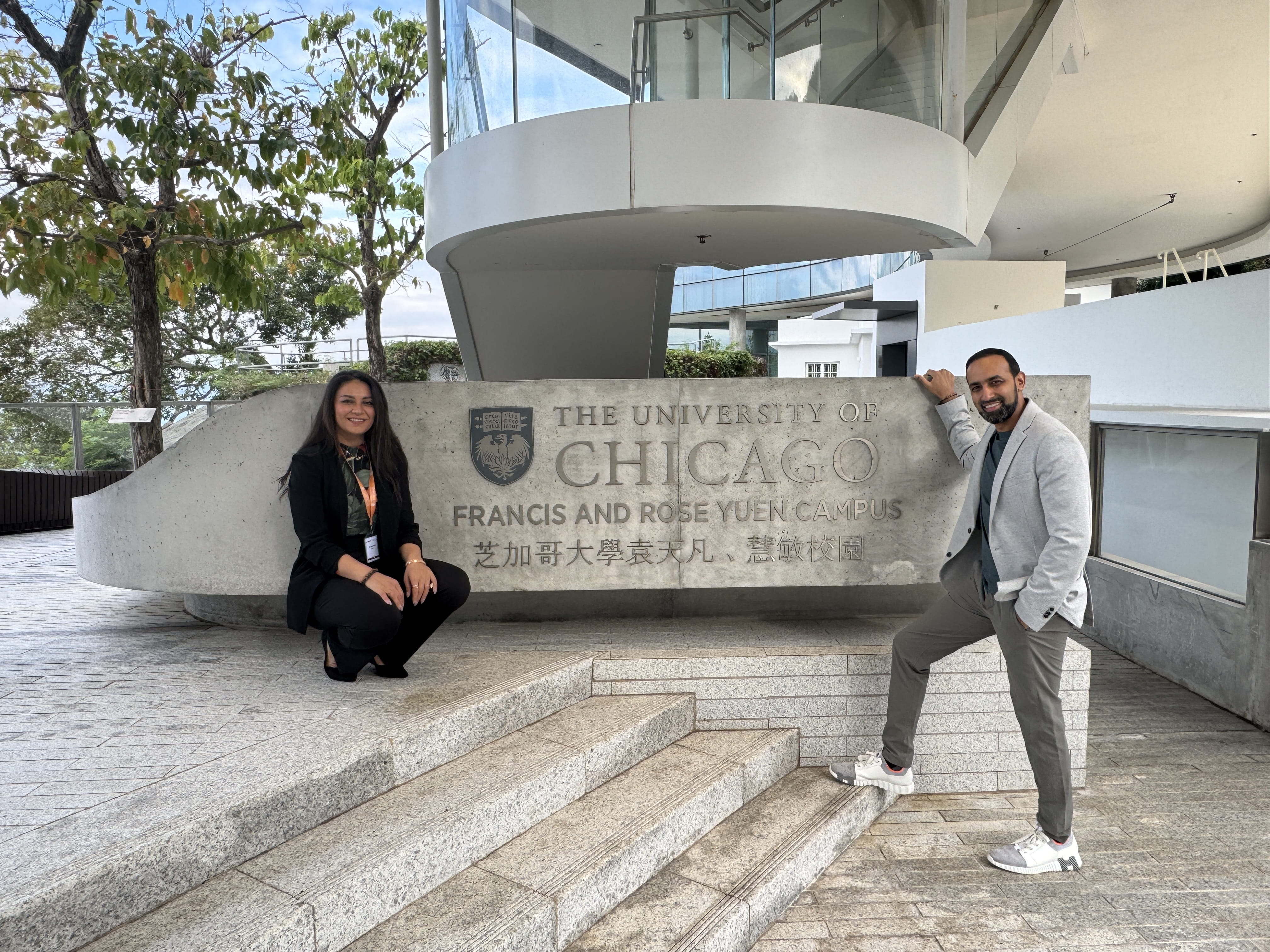 Anushka and Abhishek in front of Chicago Booth sign in Hong Kong