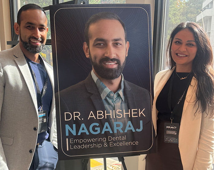 Anushka and Abhishek in front of signage with Abhishek's name on it