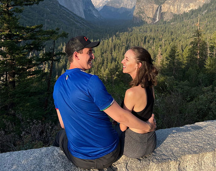 Lukas and Lorena sitting outside in nature with mountains in background