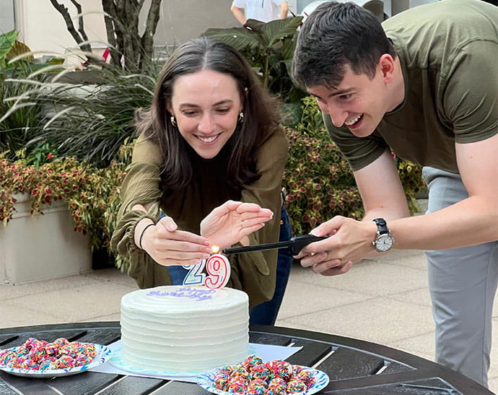 Lorena and Lukas lighting candles on birthday cake