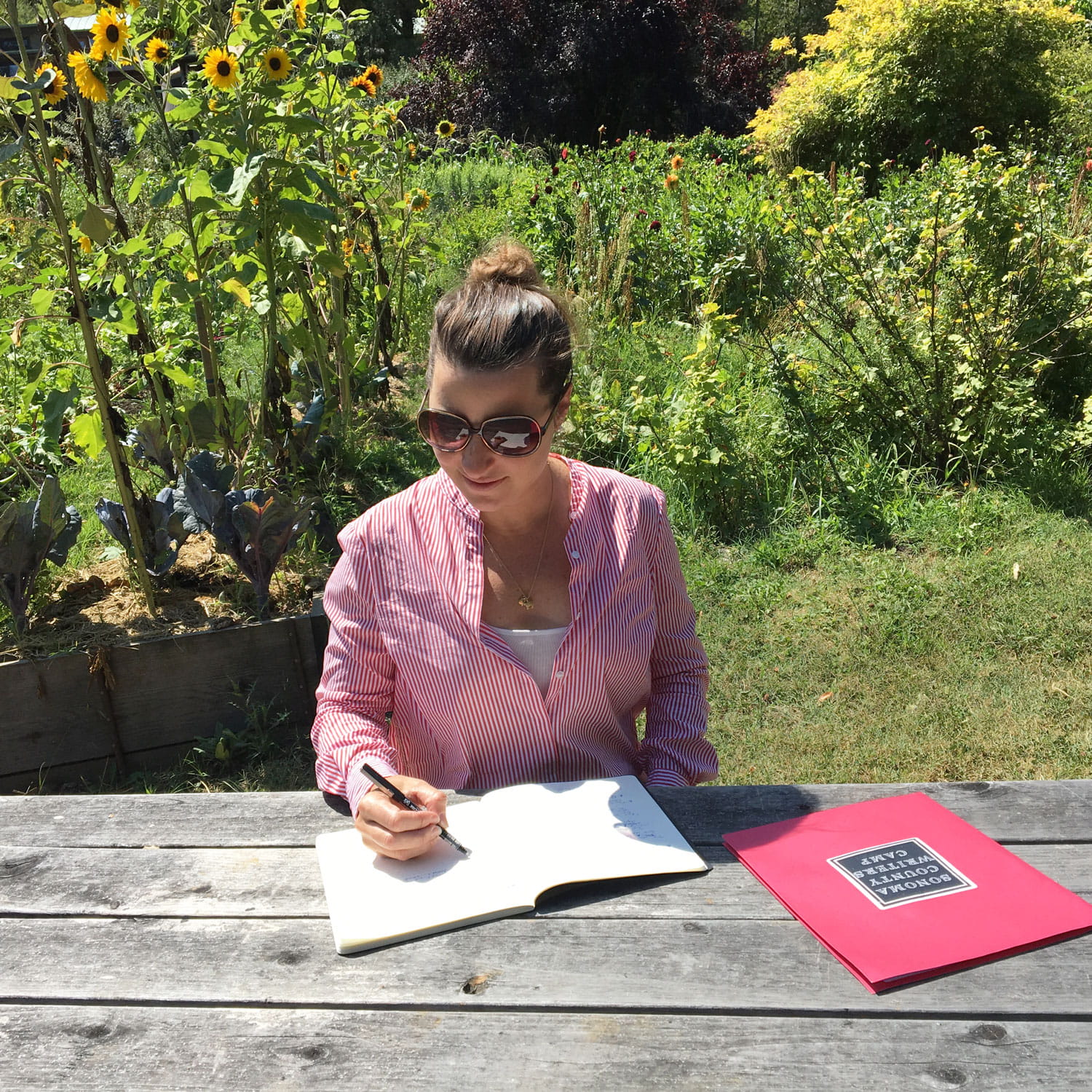 Julie McLaughlin sitting at a picnic table writing