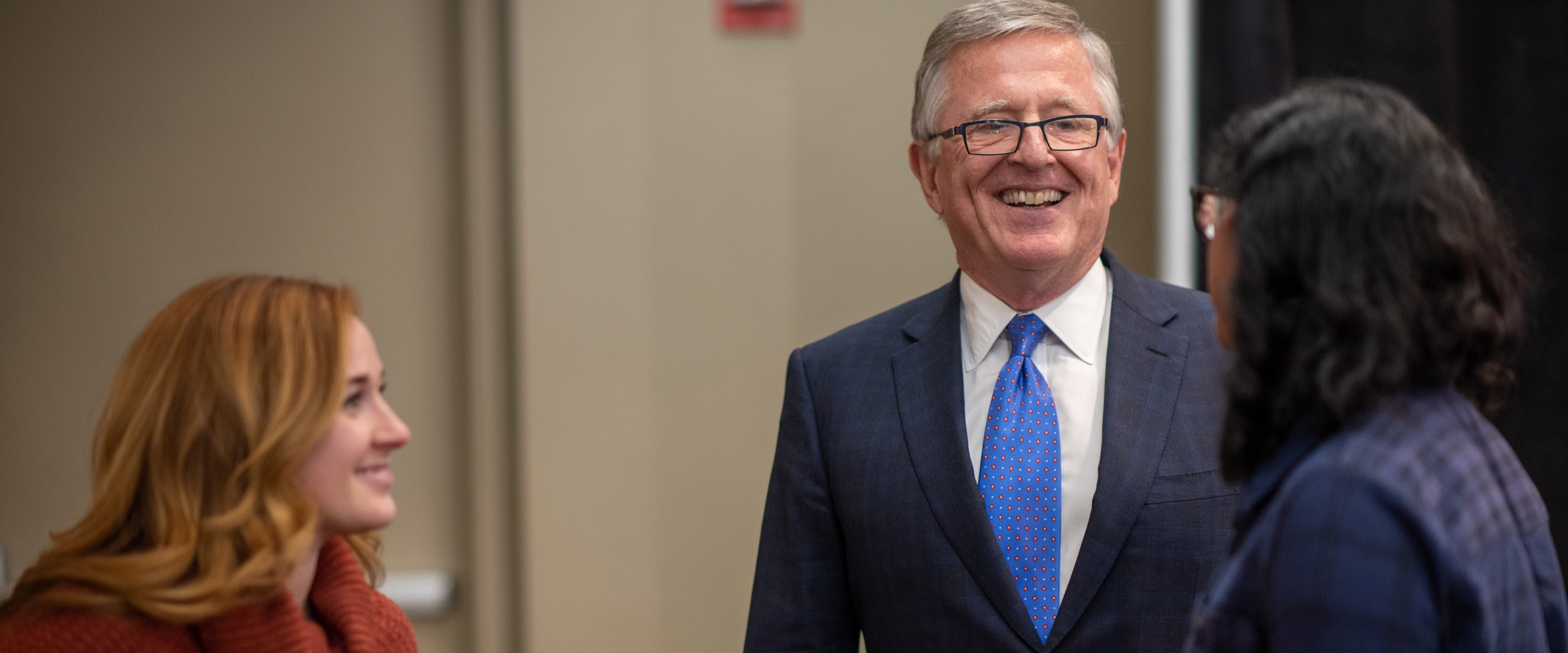 David Booth talking and smiling with two women