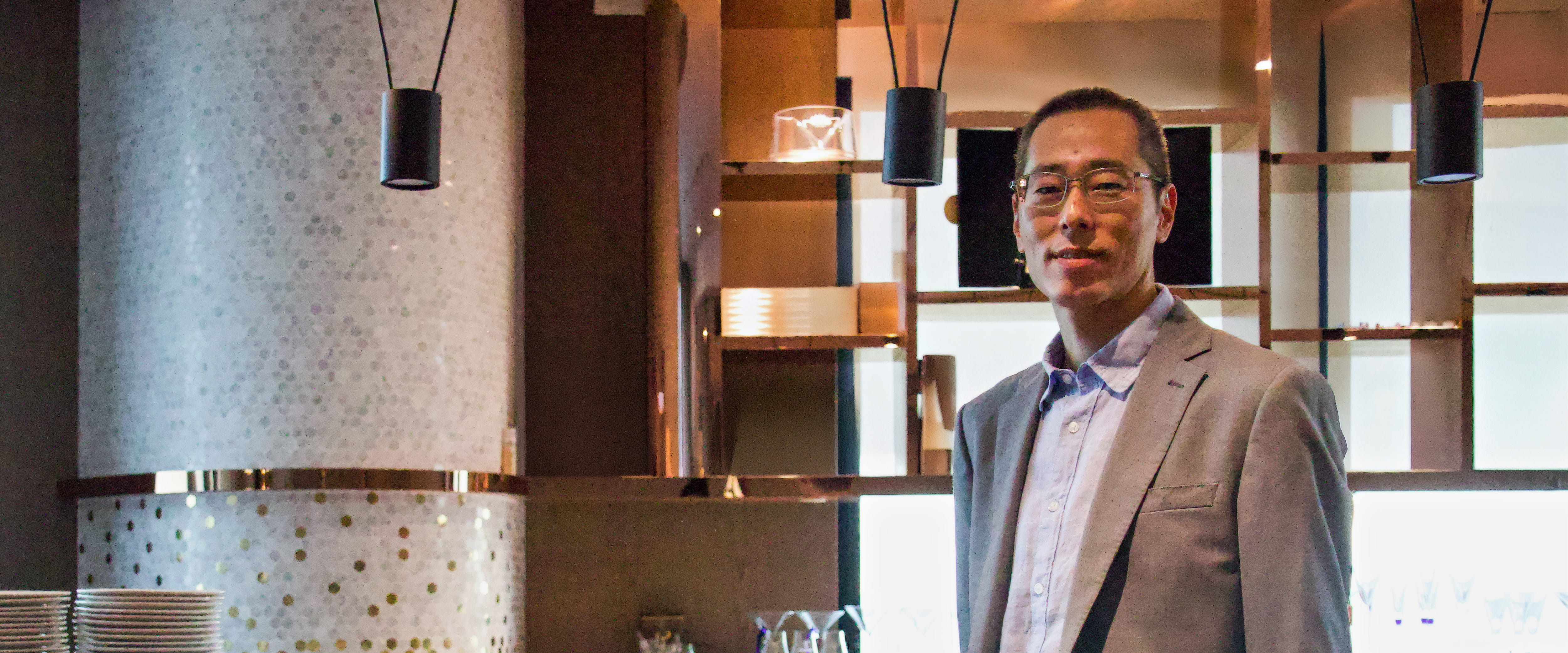 Chicago Booth alumnus Adam Peach standing and wearing a blazer.