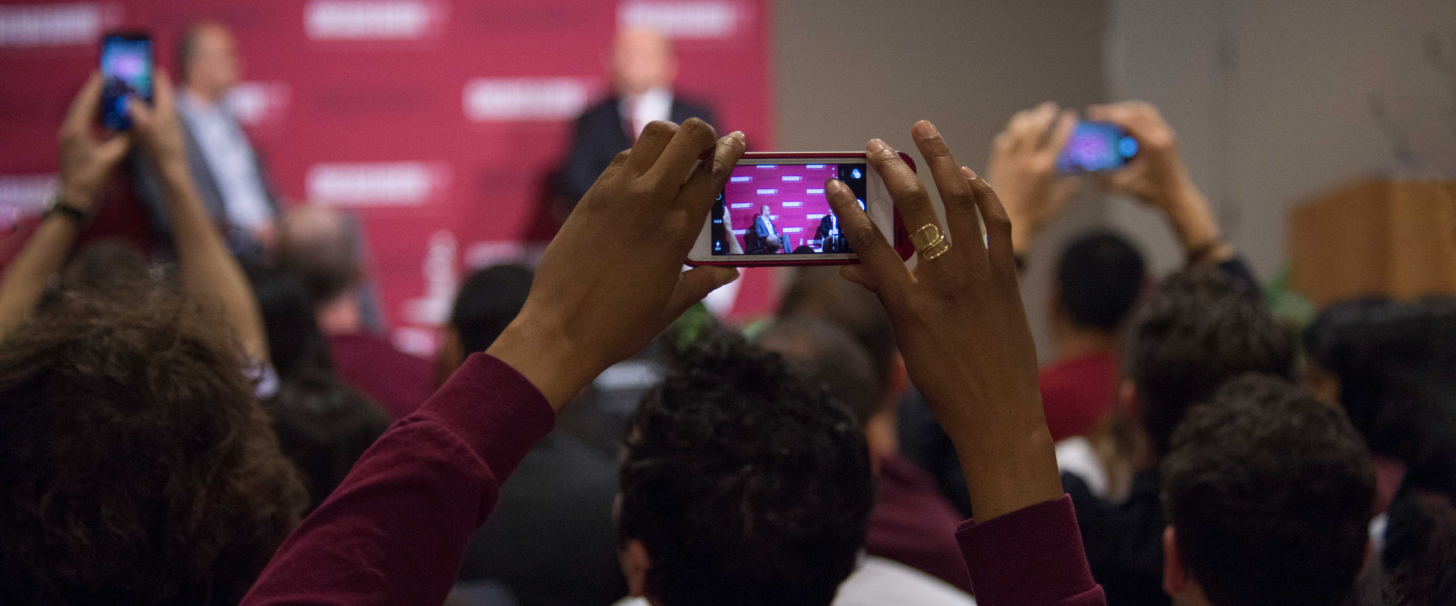 Man filming a Booth event with his cell phone 