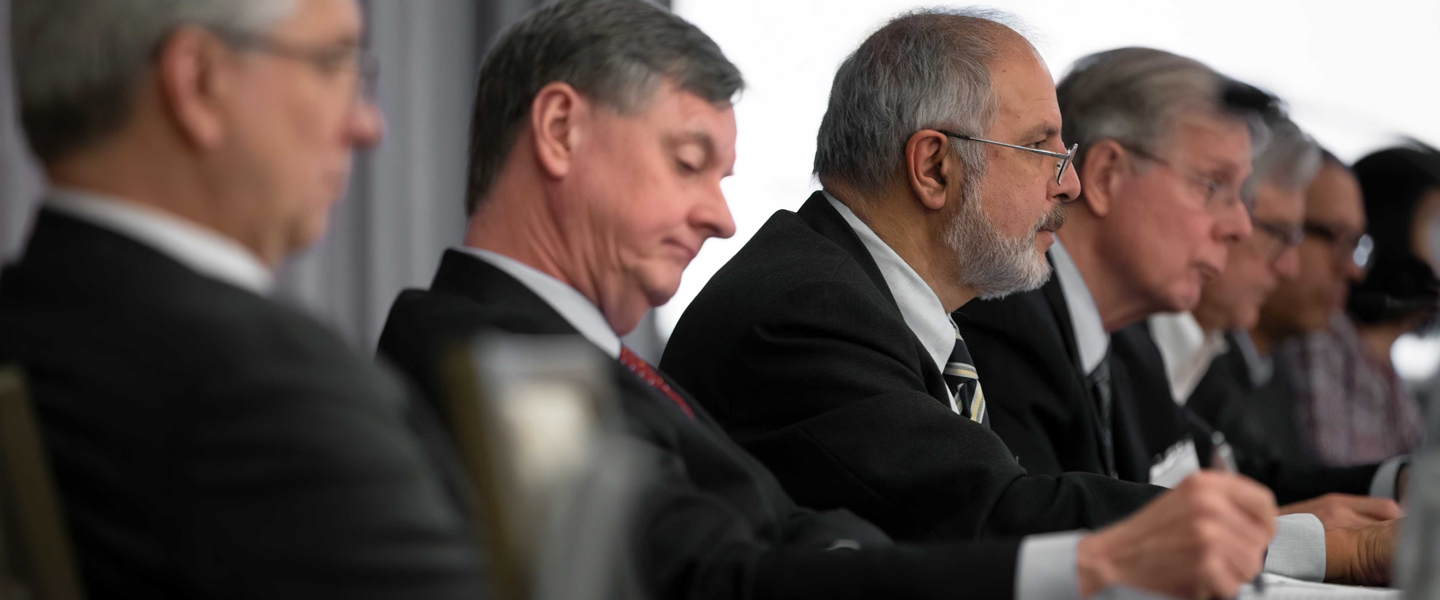 middle aged men sitting in board room