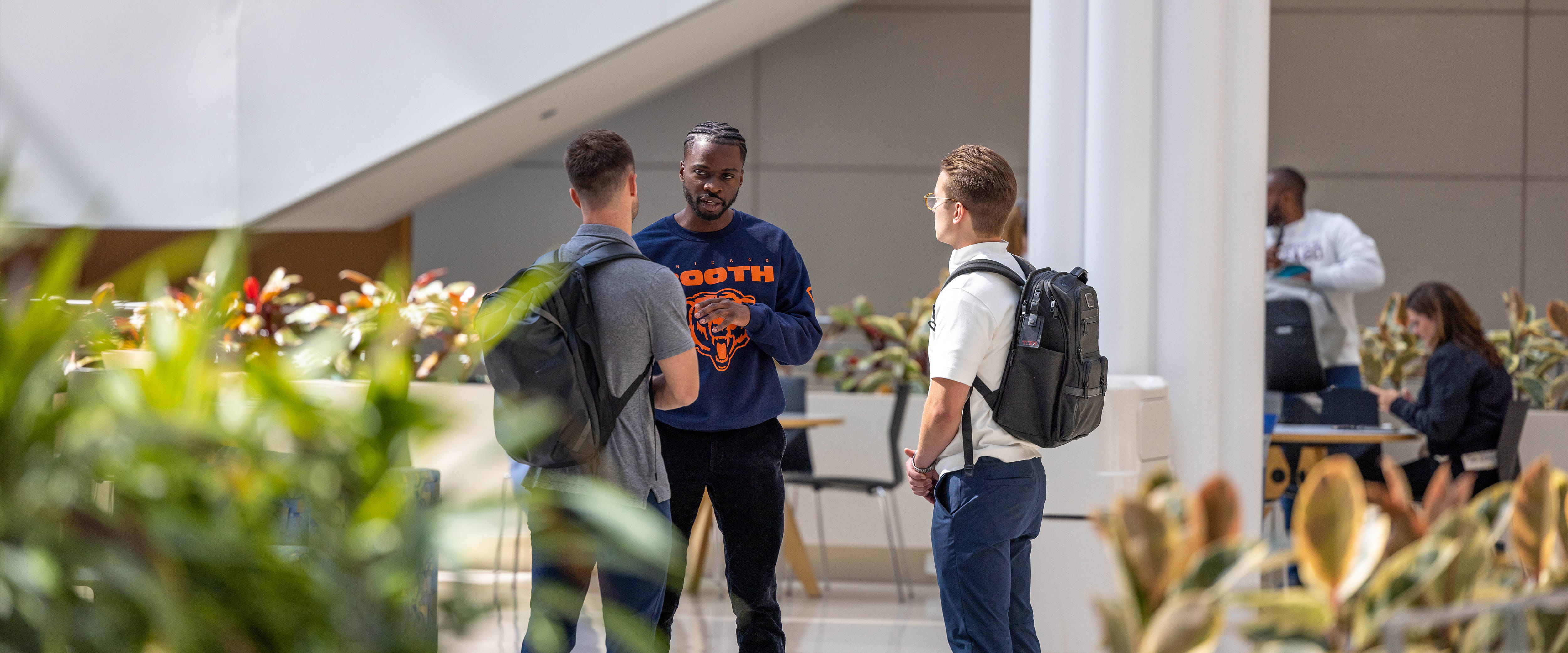 Three students converse in Harper Center